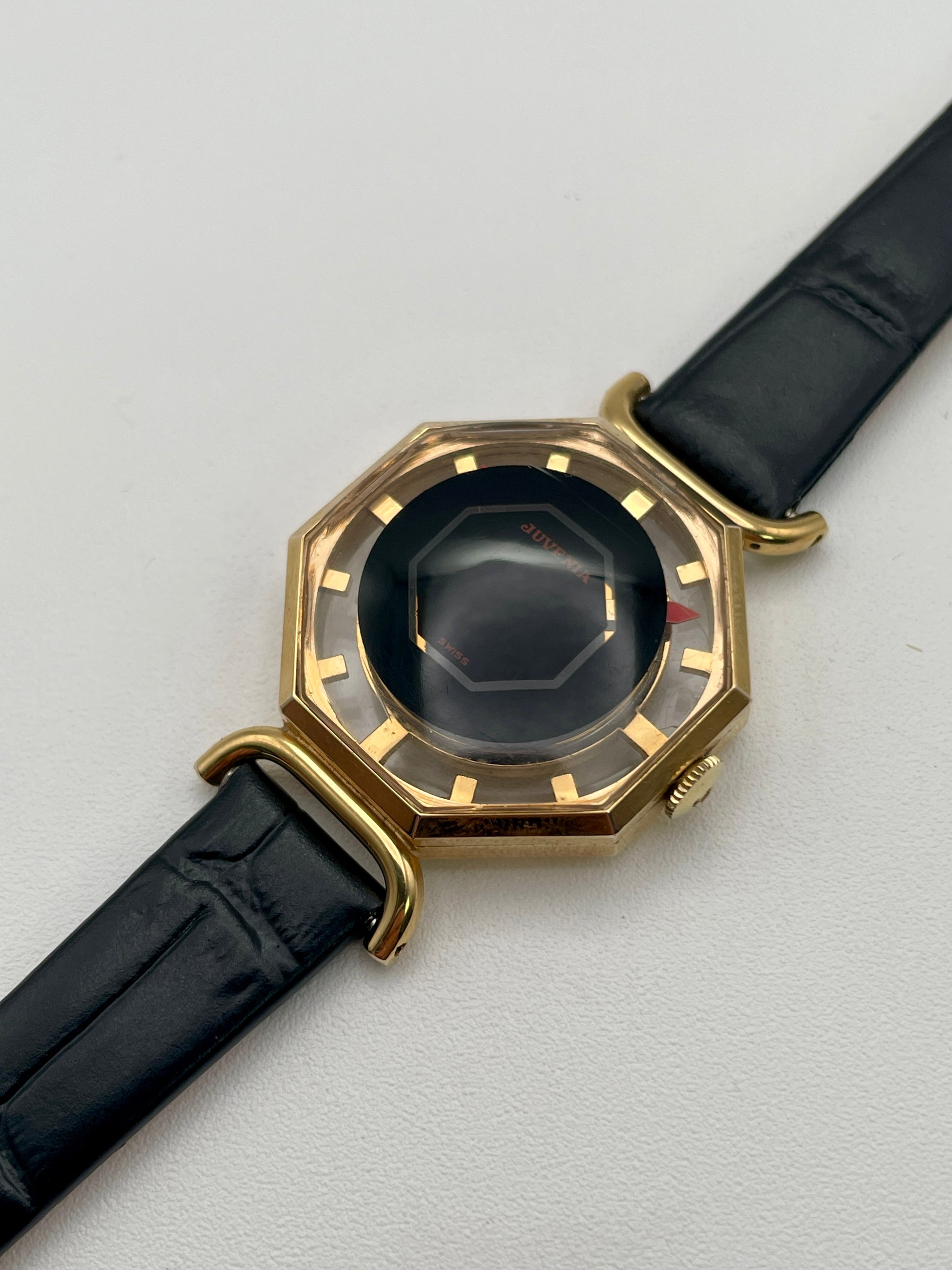 Diagonal view from right highlighting the gold-tone case and black dial of the Juvenia Octagion

