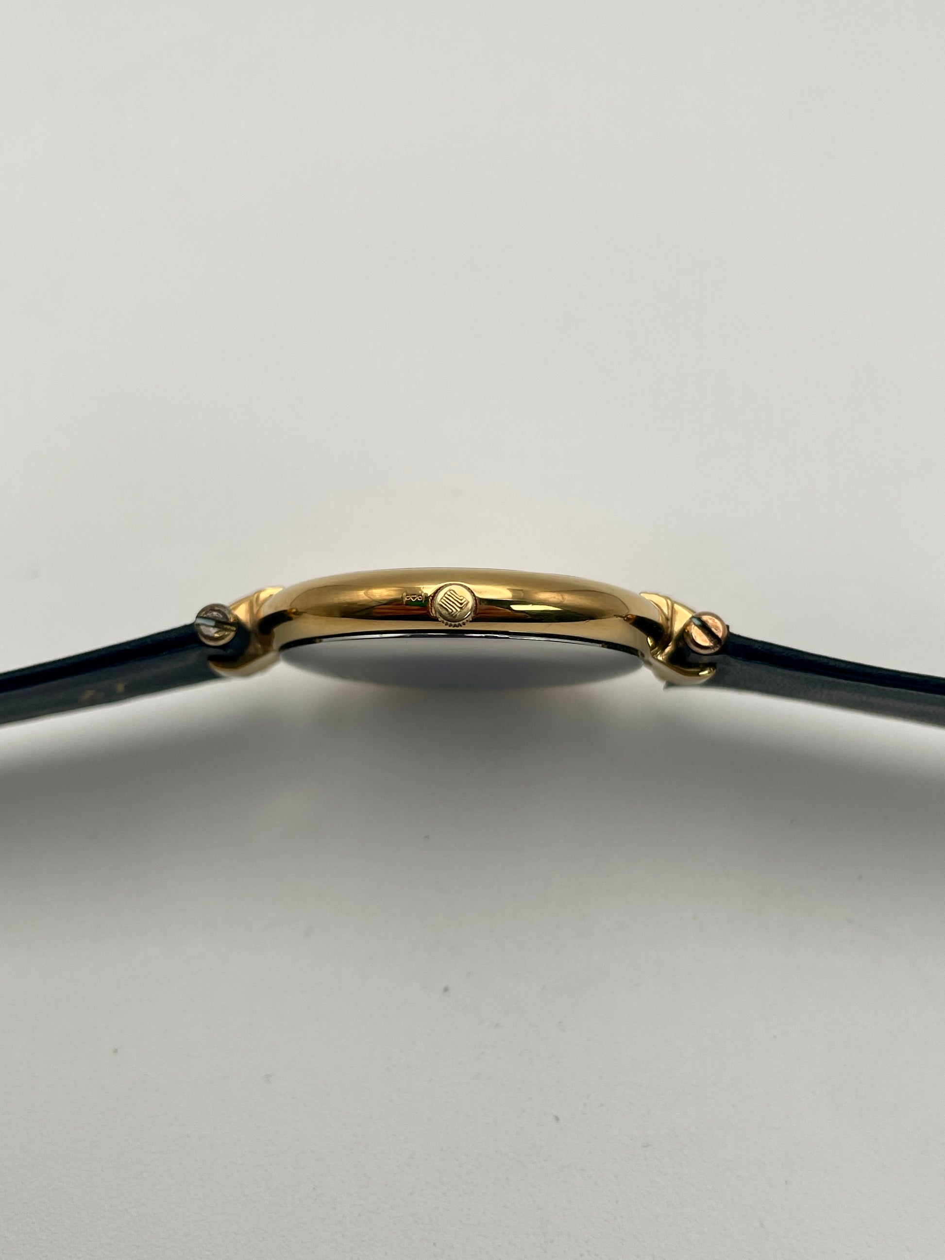 Side view of the thin gold-tone case of the Lanvin Paris Vintage Watch and the stamped crown