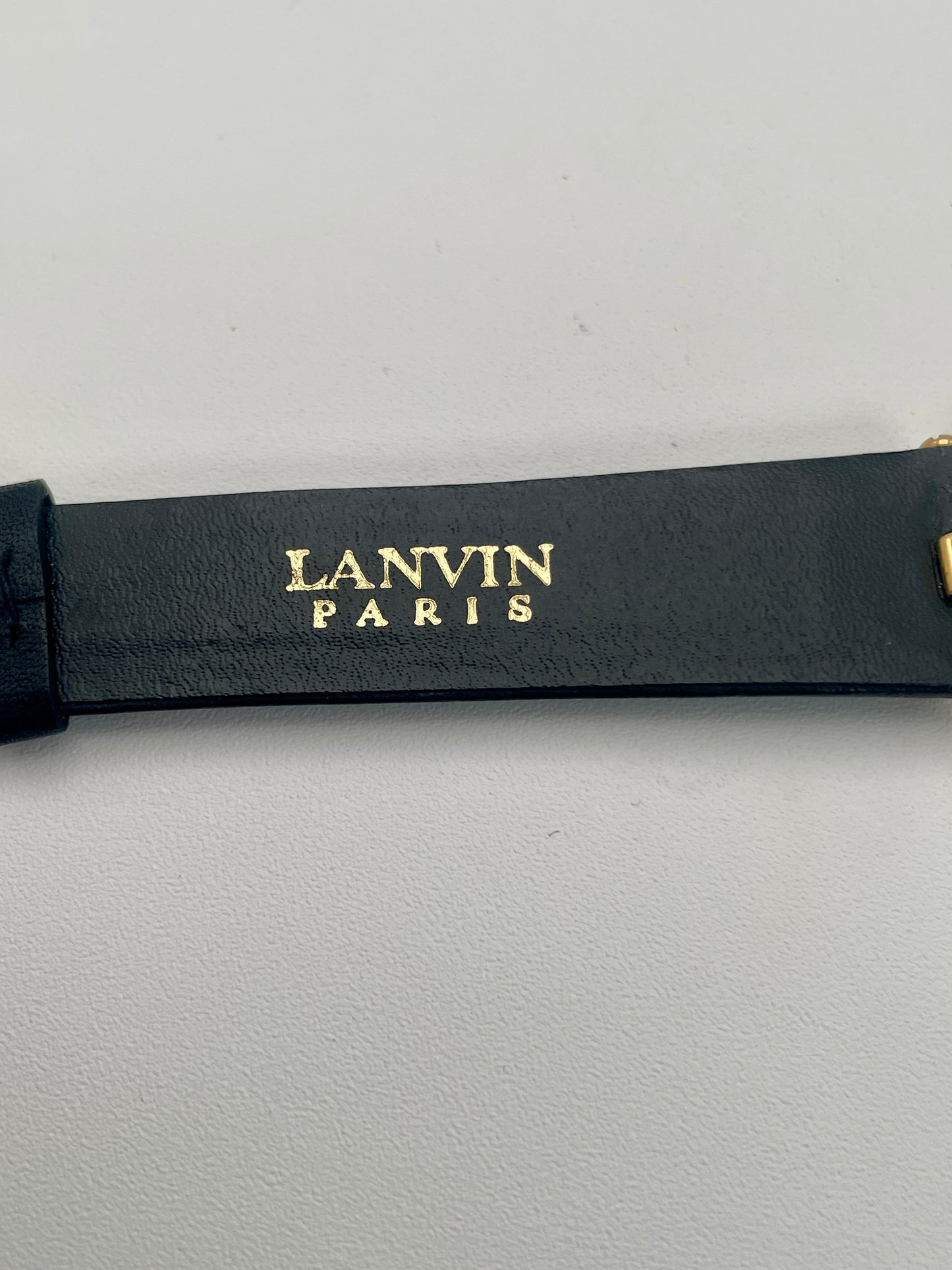 Closeup of the Lanvin Paris Vintage Gold Watch black leather strap
