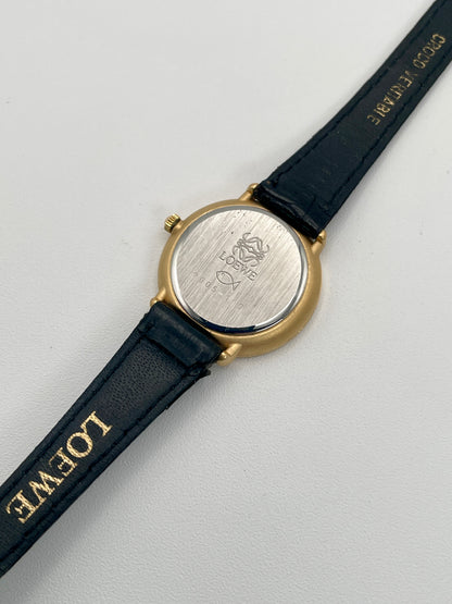 View of the caseback engraved with Loewe branding and fish logo, paired with black leather strap.