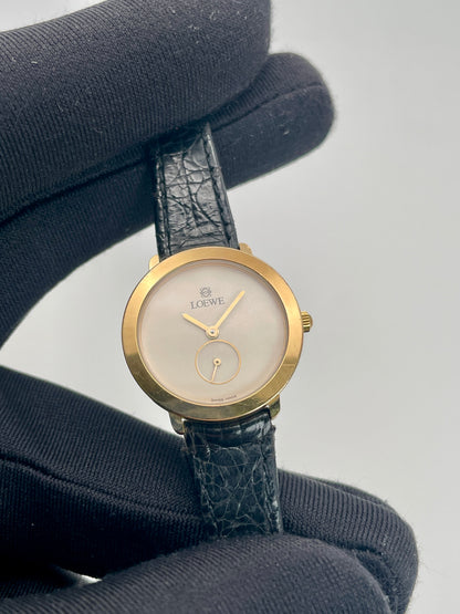 Close-up view highlighting the white dial, sub-seconds circle, and Loewe logo.