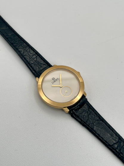 Loewe Calatrava Vintage Women's Watch in gold case with black leather strap showing white dial and small seconds subdial.