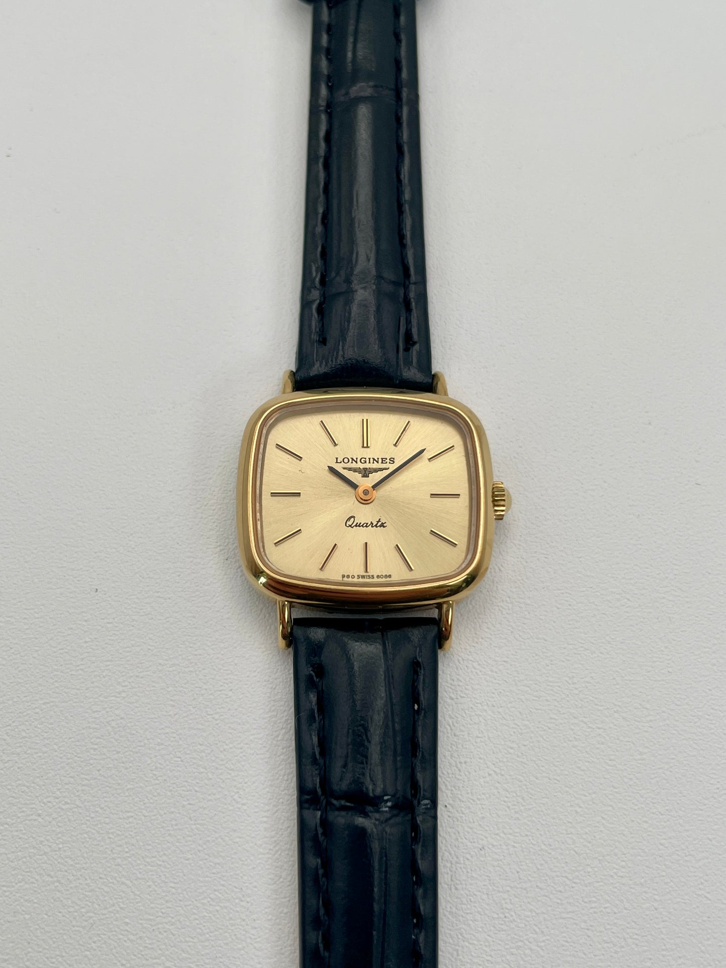 Longines 6068.2 vintage women's watch in gold-tone case with black leather strap, photographed flat from the front
