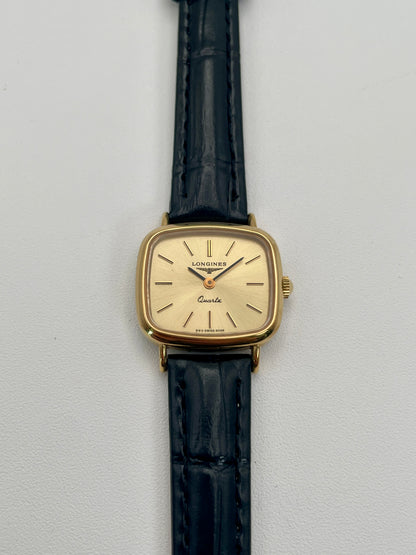 Longines 6068.2 vintage women's watch in gold-tone case with black leather strap, photographed flat from the front
