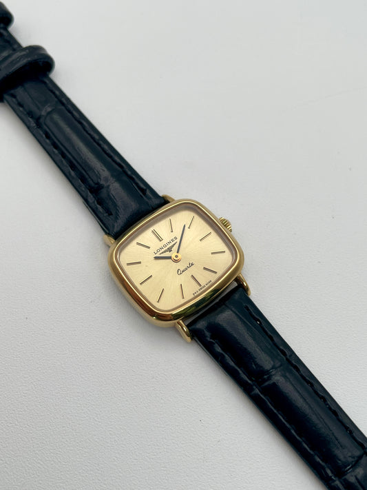 Longines 6068.2 vintage women's watch in gold-tone case with black leather strap, photographed flat from the front
