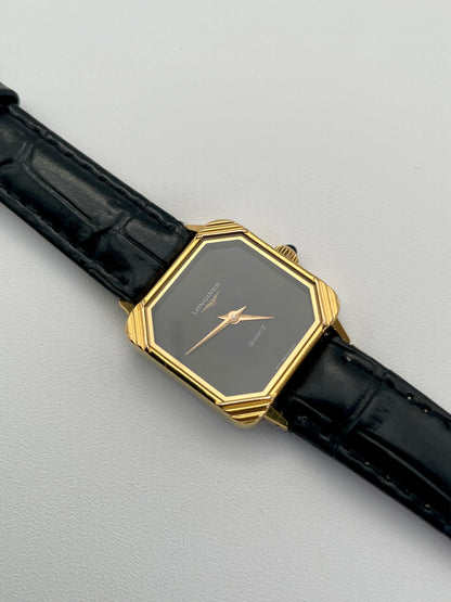 Diagonal view of Longines Neo-Vintage Quartz watch with gold case, black dial, and black leather strap.