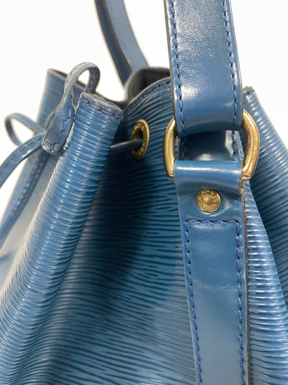 Detailed view of the gold-tone buckle and eyelets on the Louis Vuitton Petit Noé Shoulder Bag in Toledo Blue Leather.