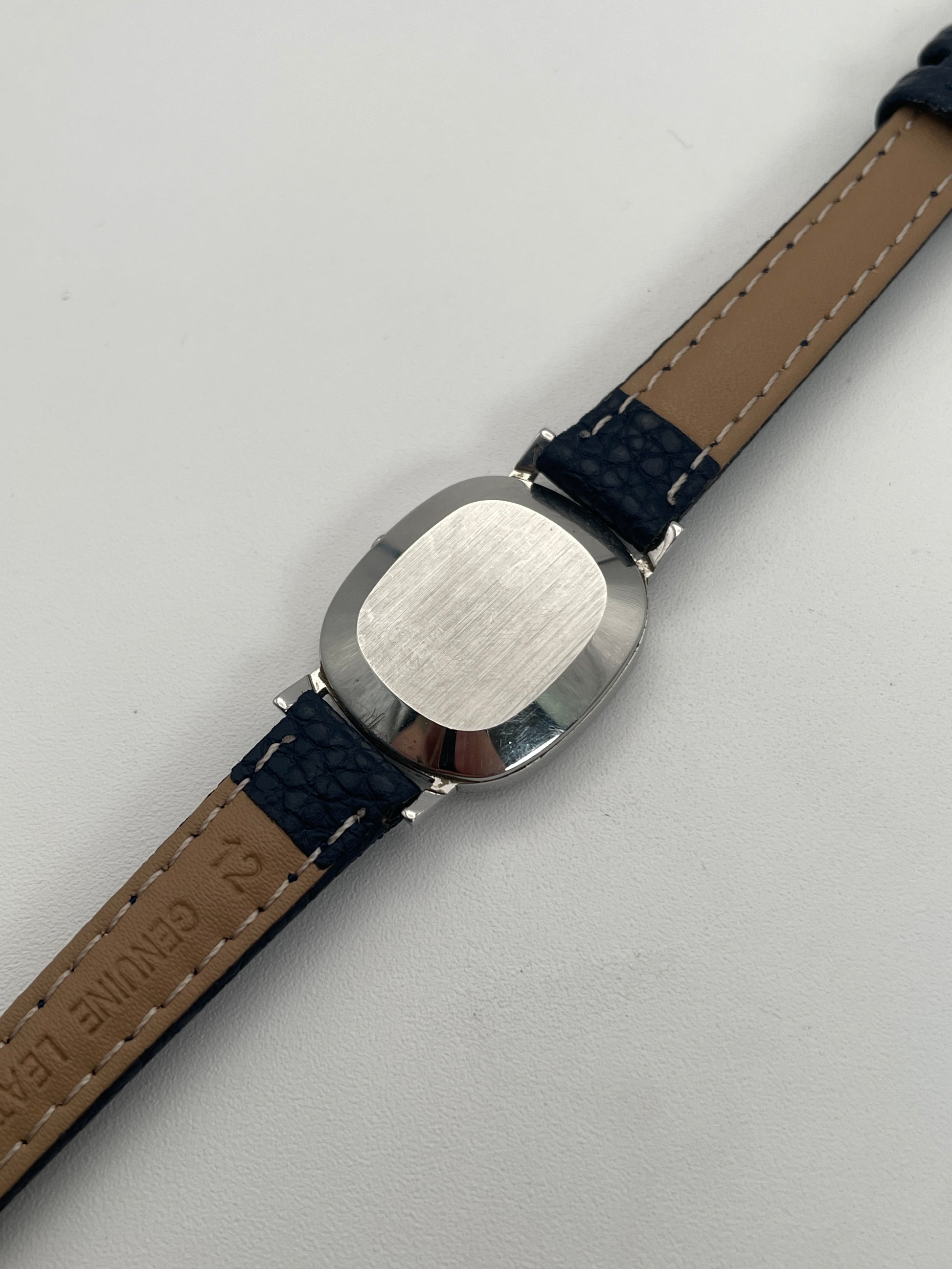 Caseback view of Omega 591.0016 vintage quartz watch showing the plain stainless steel back and blue leather strap.