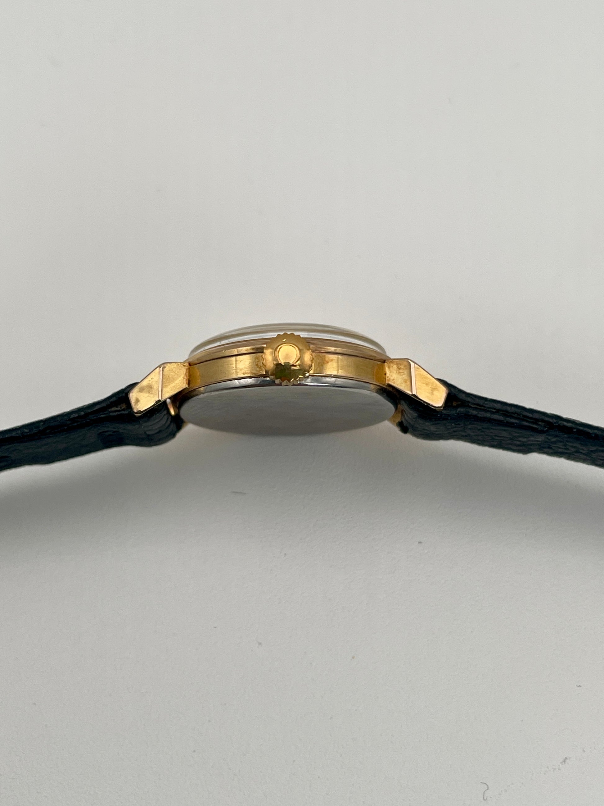 Side view of Omega Art Deco gold ladies watch showcasing the crown and gold case details.