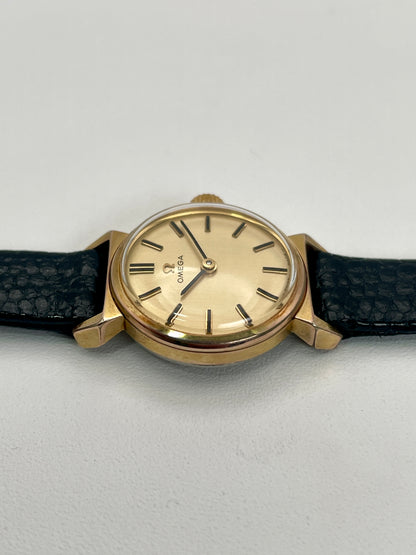 Detailed view of Omega Art Deco gold watch with classic black leather strap and champagne dial.