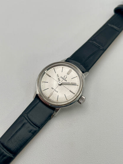 Angled view of the Omega De Ville 515.007 vintage watch highlighting its polished stainless steel case and elegant silver sunburst dial.