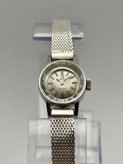 Front view of the Omega De Ville watch with cut glass crystal, displaying the silver dial and mesh bracelet