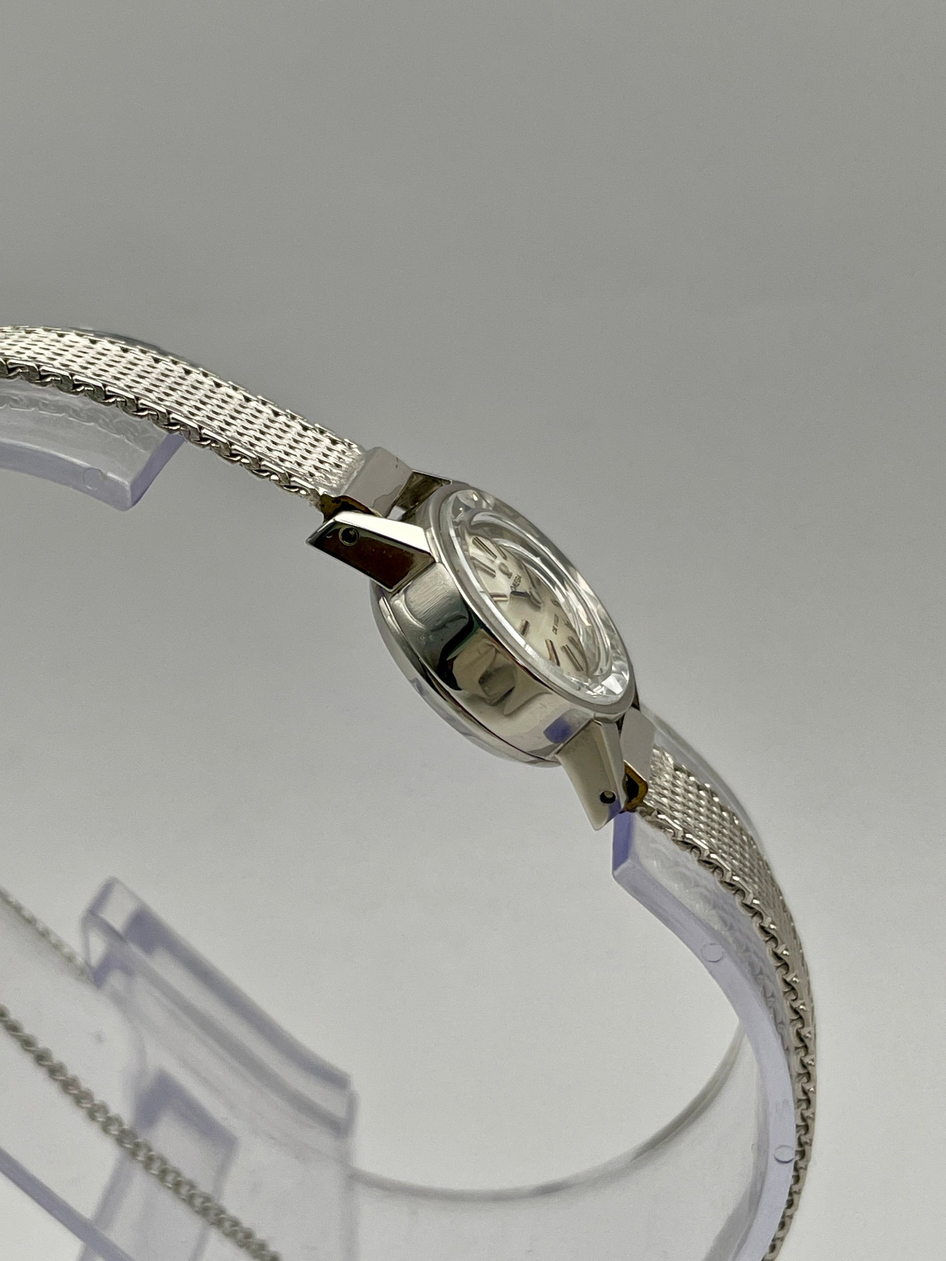 Side view of the Omega De Ville watch, showcasing the cut glass crystal and stainless steel case