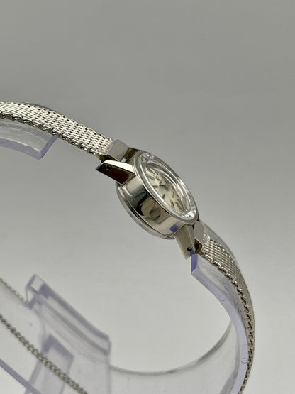 Side view of the Omega De Ville watch, showcasing the cut glass crystal and stainless steel case