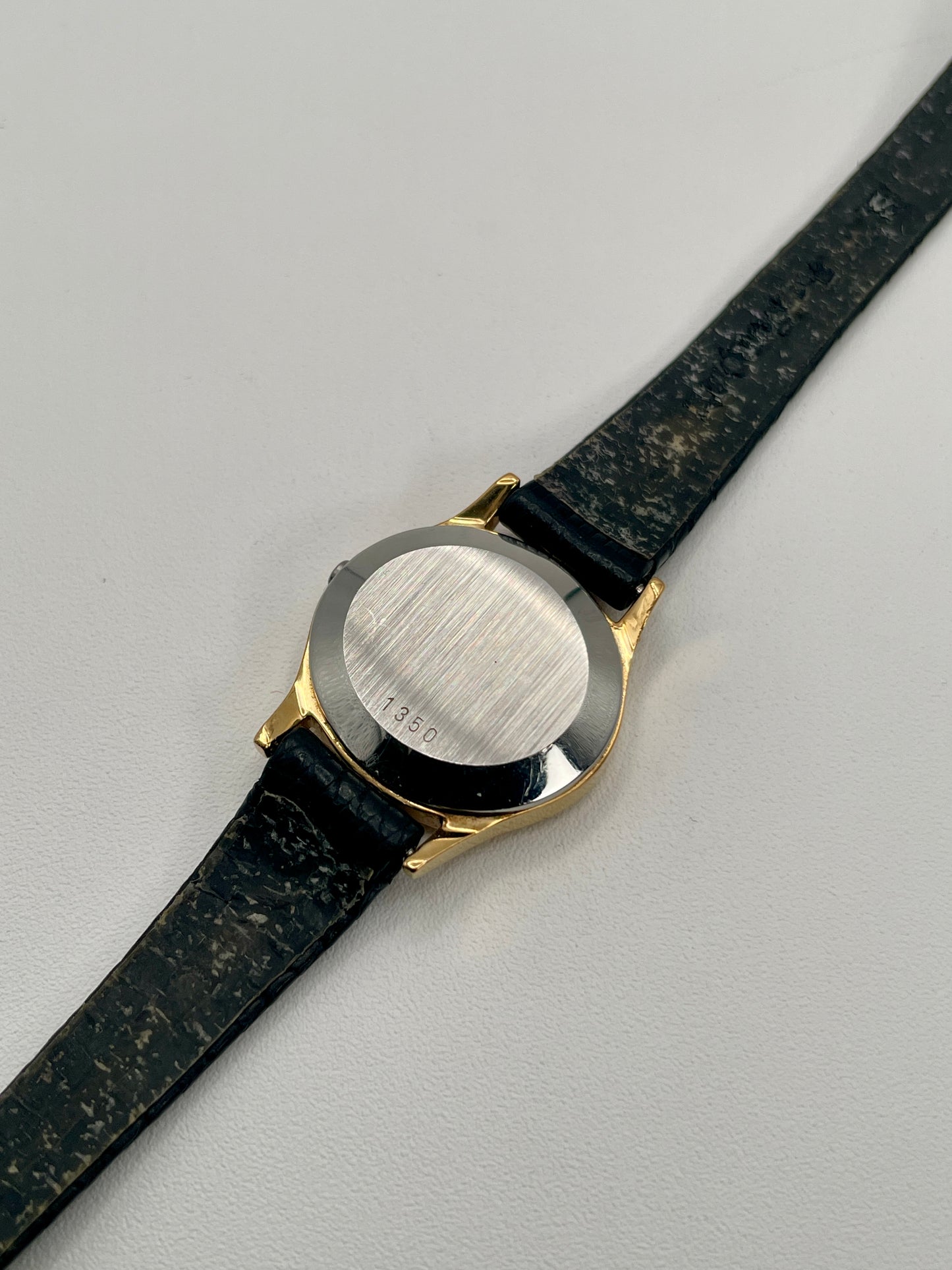 Close-up of the caseback of the Omega De Ville 1350 with brushed steel and serial engraving.