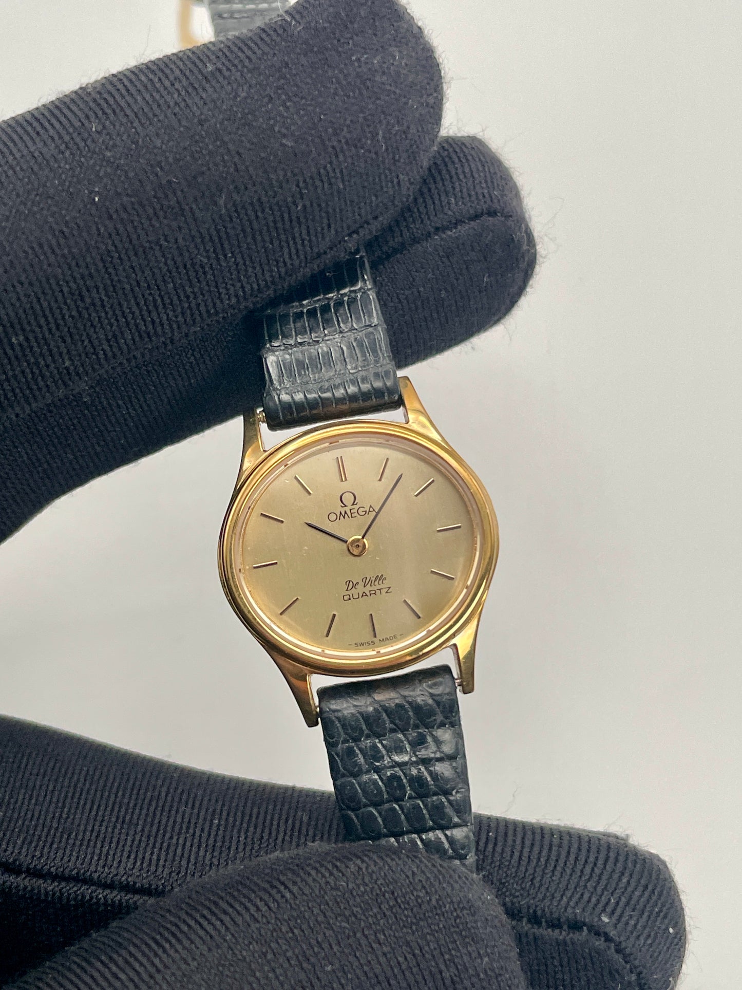 Close-up front view of the Omega De Ville 1350 showing the gold-tone dial and black leather strap.