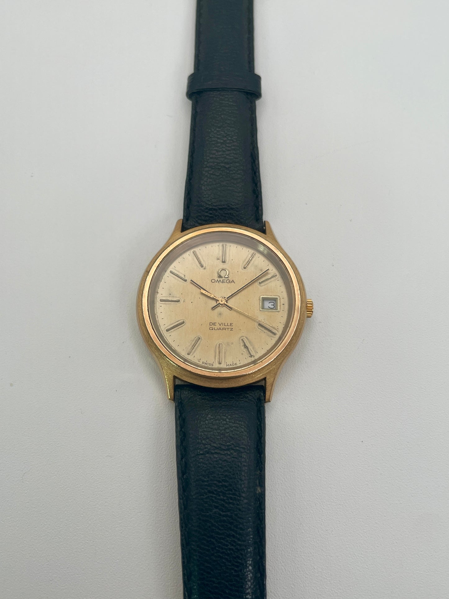Omega De Ville 192.0033 vintage watch in gold with black strap, front face view

