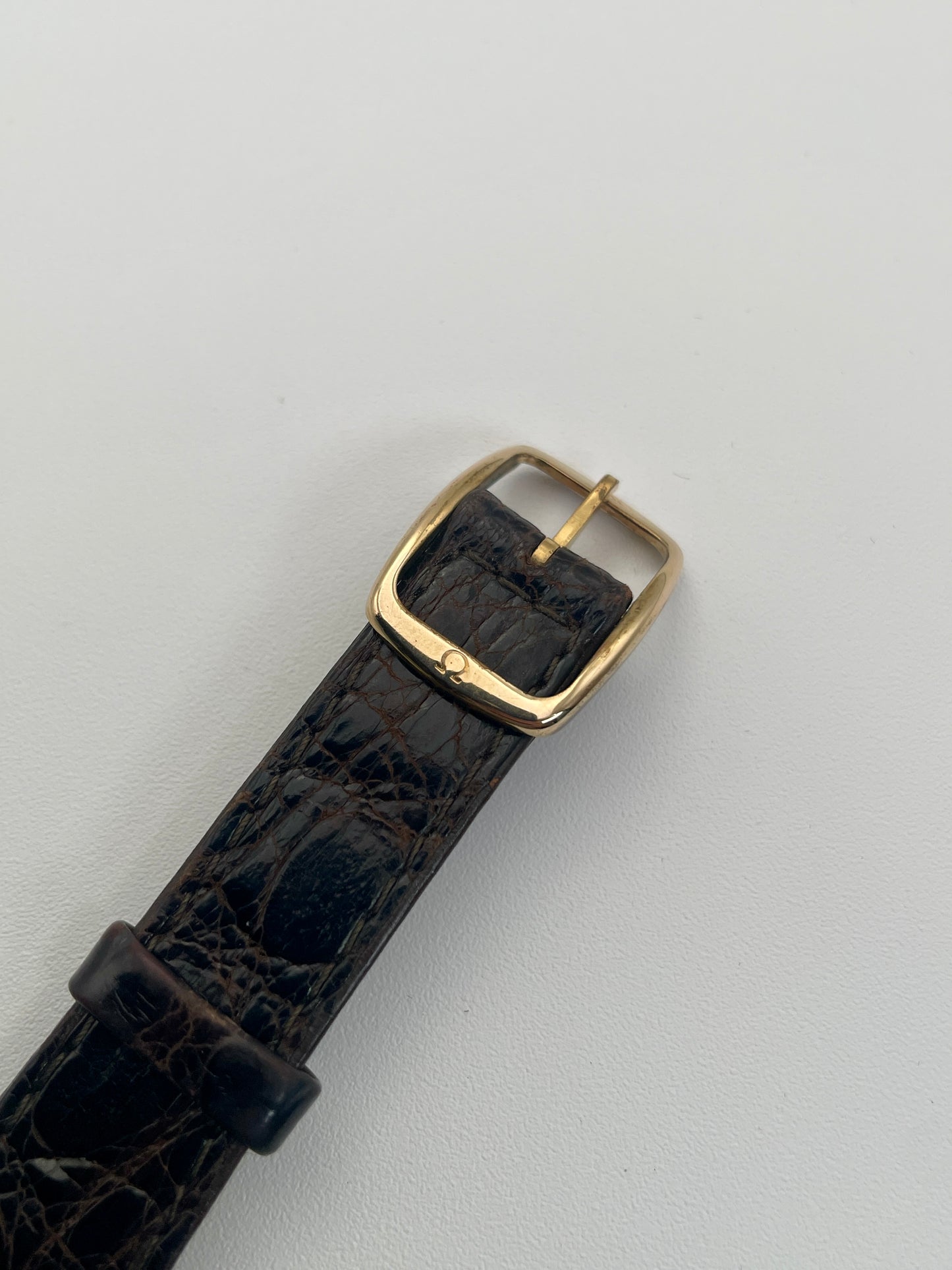 Close-up view of the buckle on Omega Deville Classic Ref 191.0130 gold watch with a black leather strap.