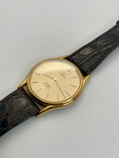 Diagonal view of Omega Deville Classic Ref 191.0130 gold watch with a round case, gold dial, and black leather strap.