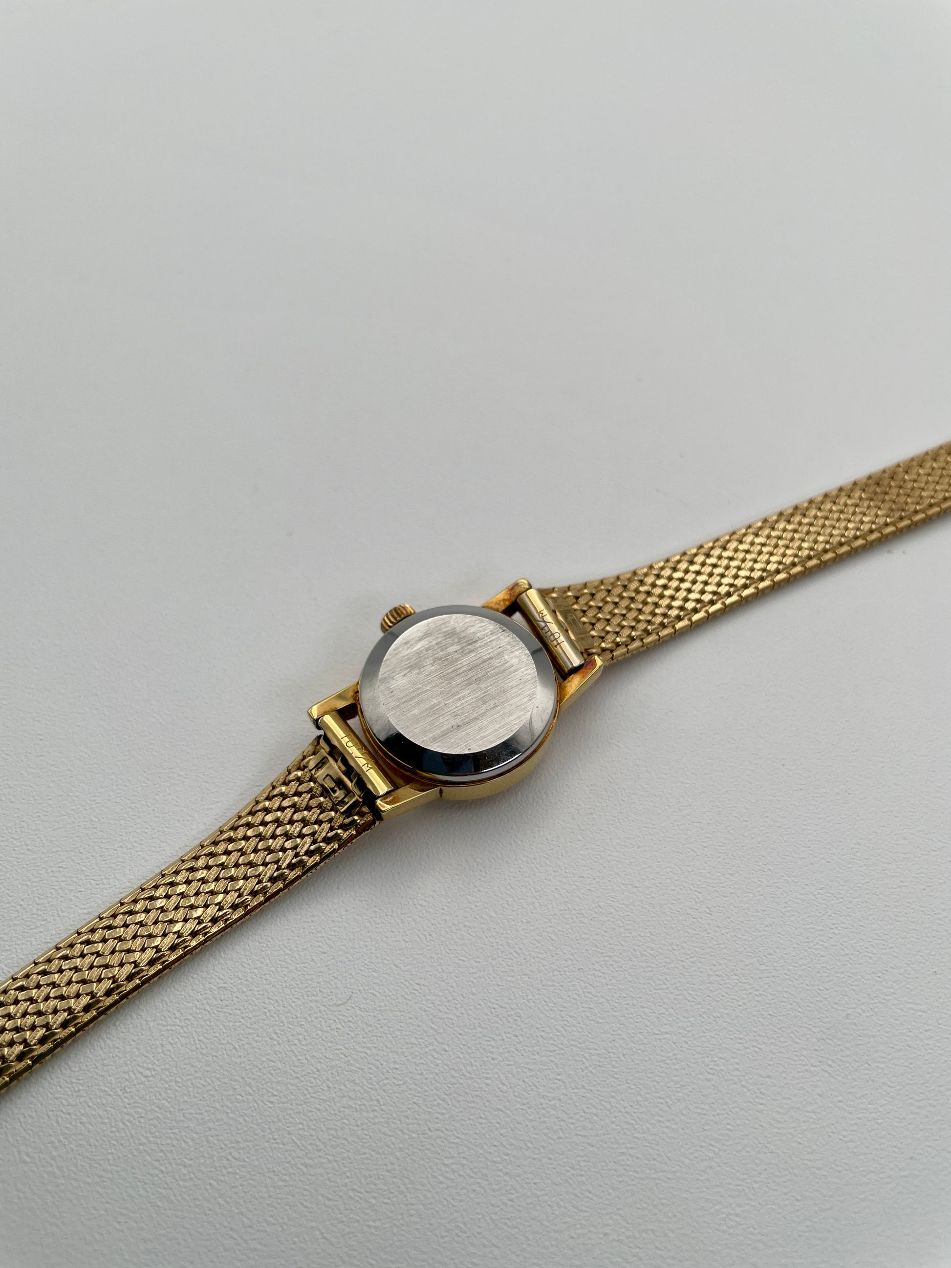 Caseback view of the vintage Omega De Ville ladies watch in gold with mesh bracelet.