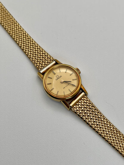 Diagonal view of the vintage Omega De Ville ladies watch in gold with mesh bracelet.