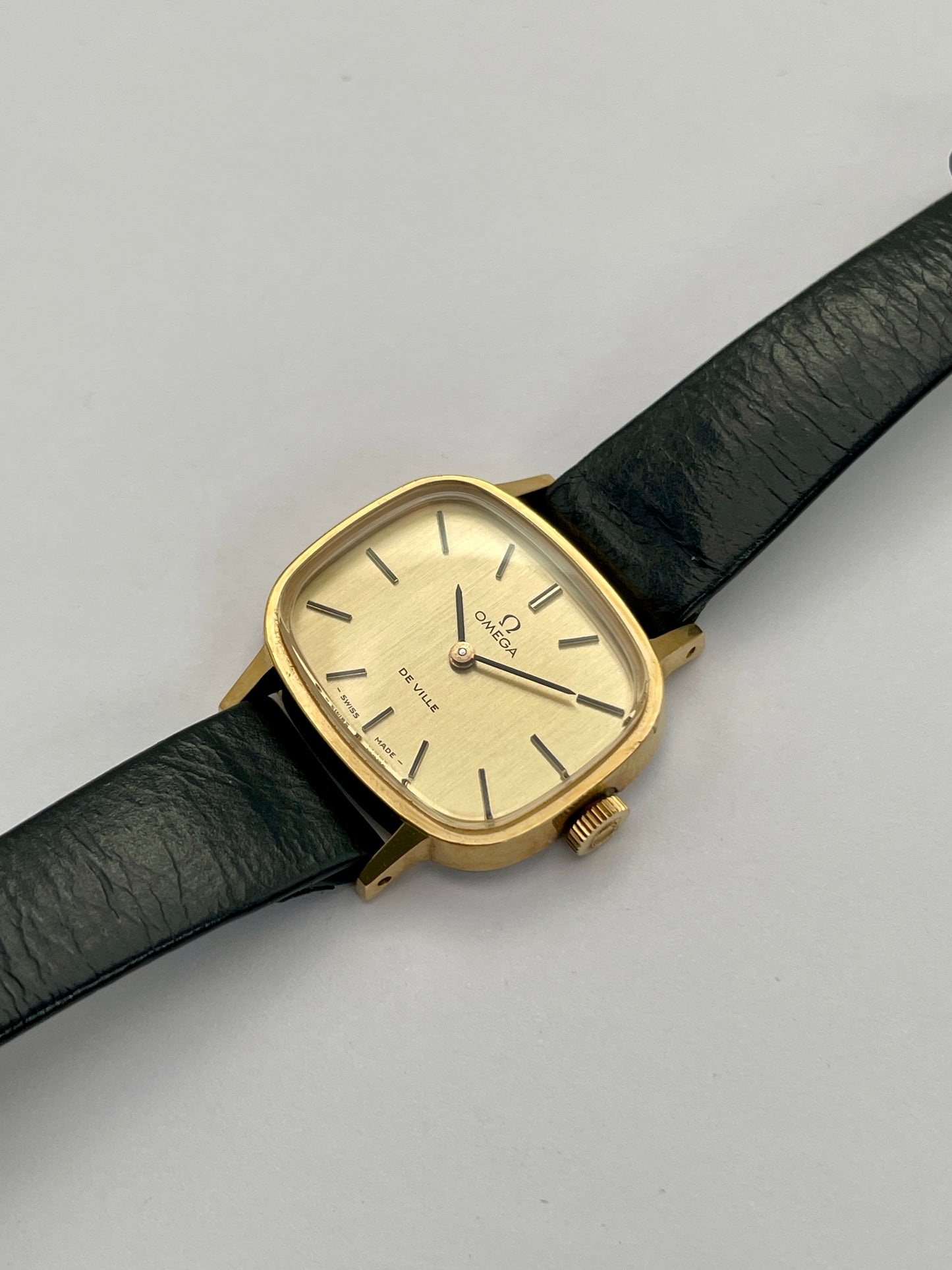 Diagonal view of Omega De Ville TV Dial watch showing the stainless steel back and black leather strap.