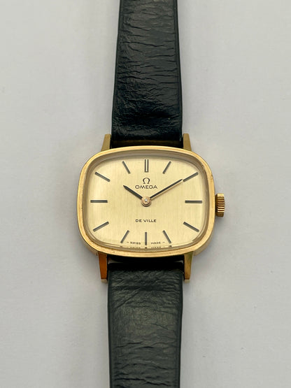 Front view of Omega De Ville TV Dial watch featuring a gold-tone square case and black leather strap.