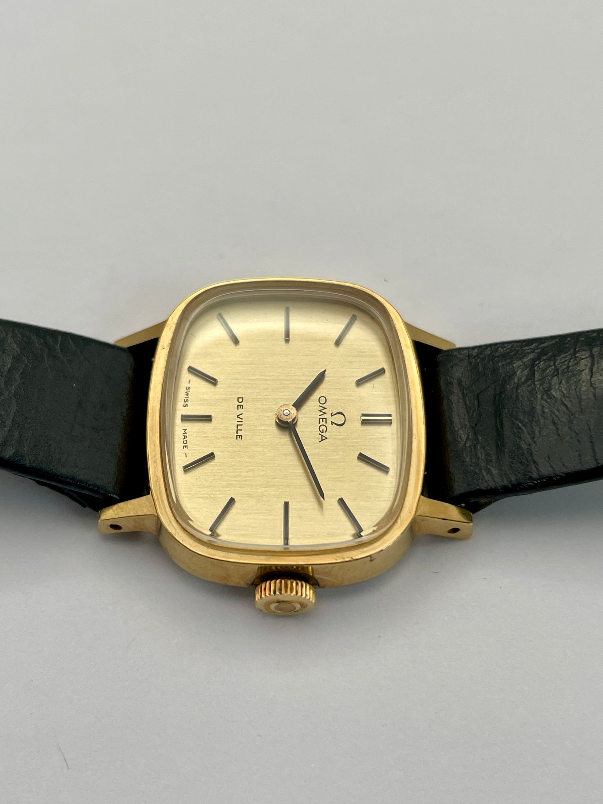 Top crown view of Omega De Ville TV Dial watch highlighting the gold-tone square case and black leather strap.