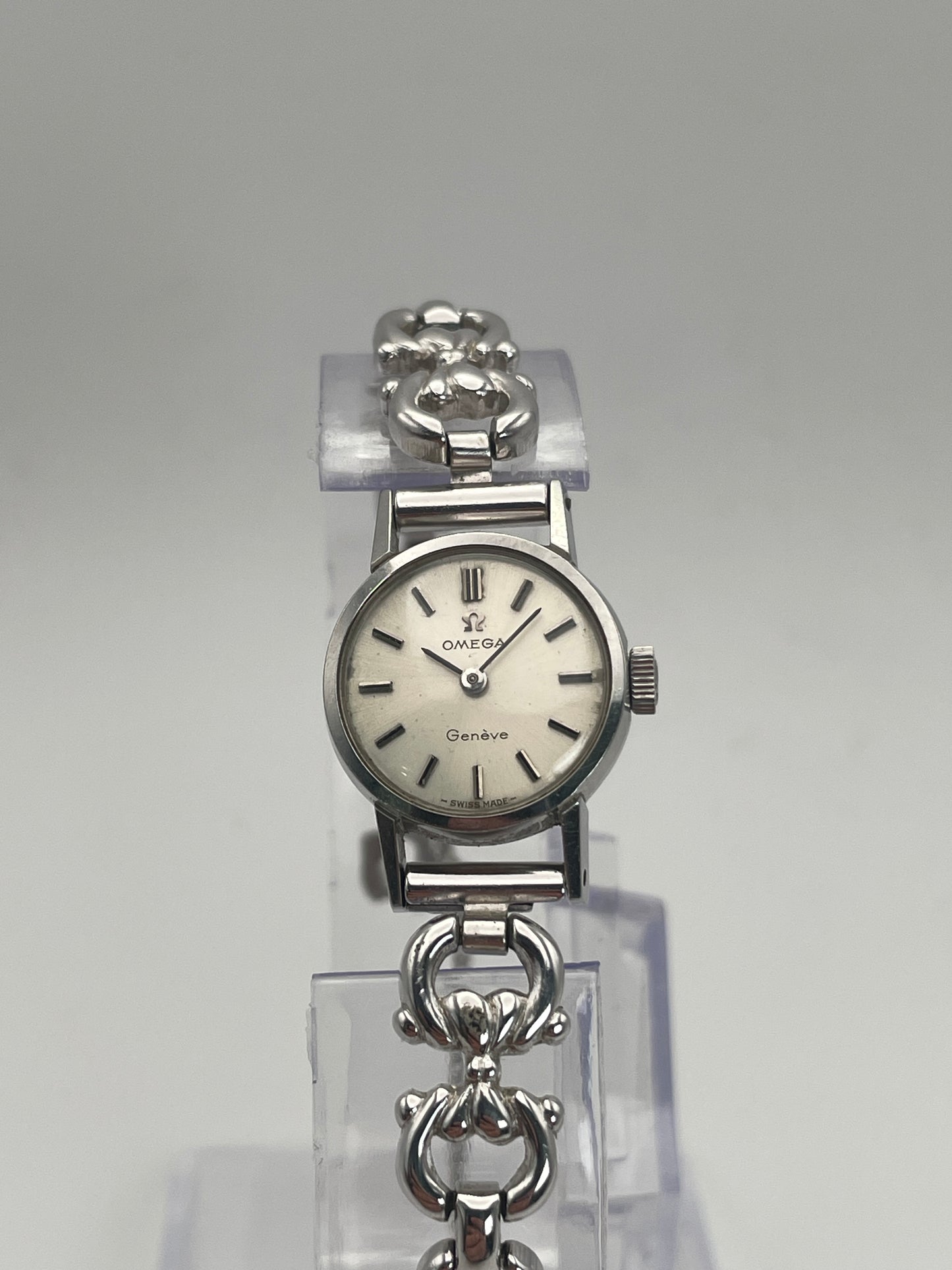 Front view of Omega Genève ladies watch in silver-tone with a round case, silver dial, and intricate bracelet.