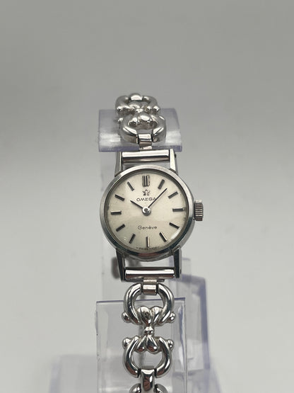 Front view of Omega Genève ladies watch in silver-tone with a round case, silver dial, and intricate bracelet.