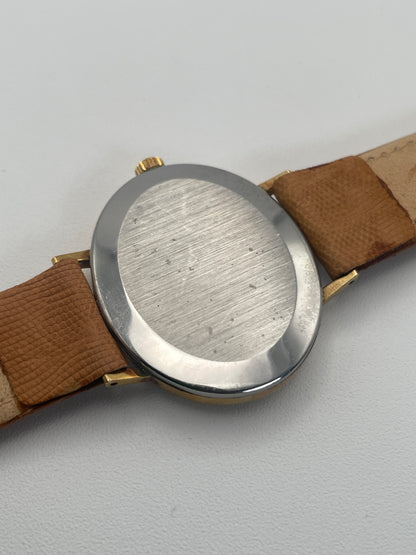 Caseback view of Omega Genève Ladies Watch with oval gold case and tan leather strap.