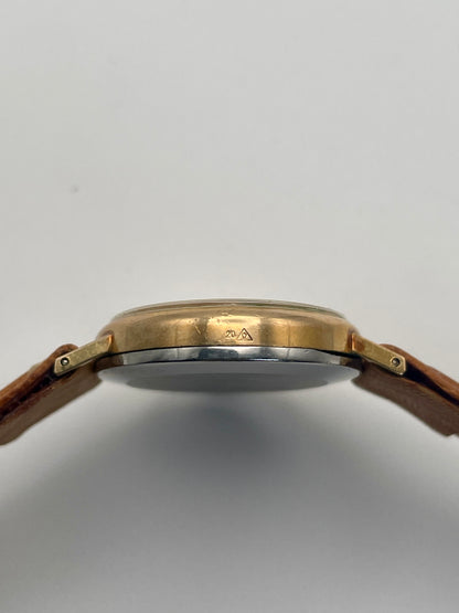 Side case view of Omega Genève Ladies Watch with oval gold case and tan leather strap.