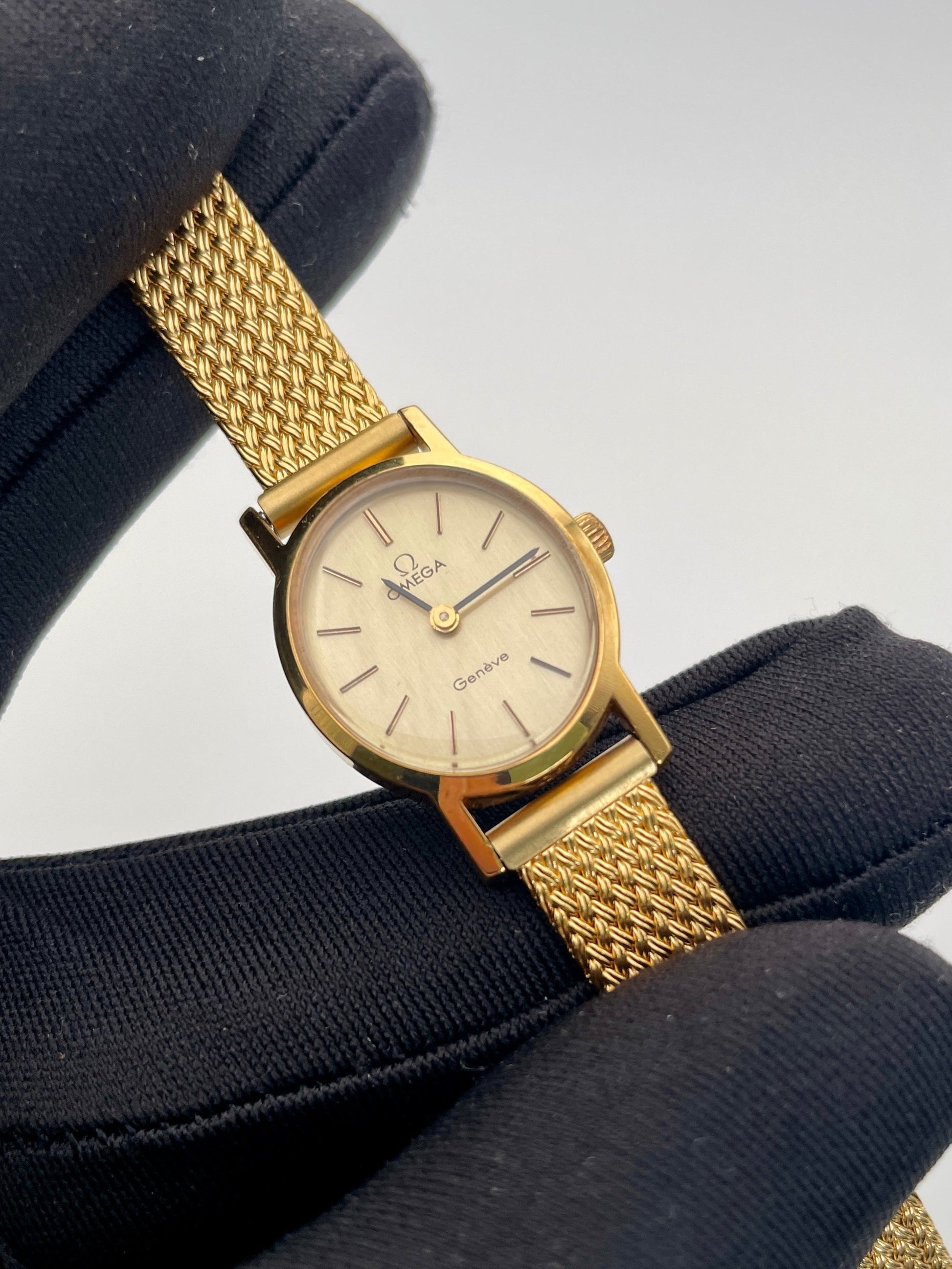 Omega Genève oval ladies watch in gold with a mesh bracelet, close-up view of the dial.
