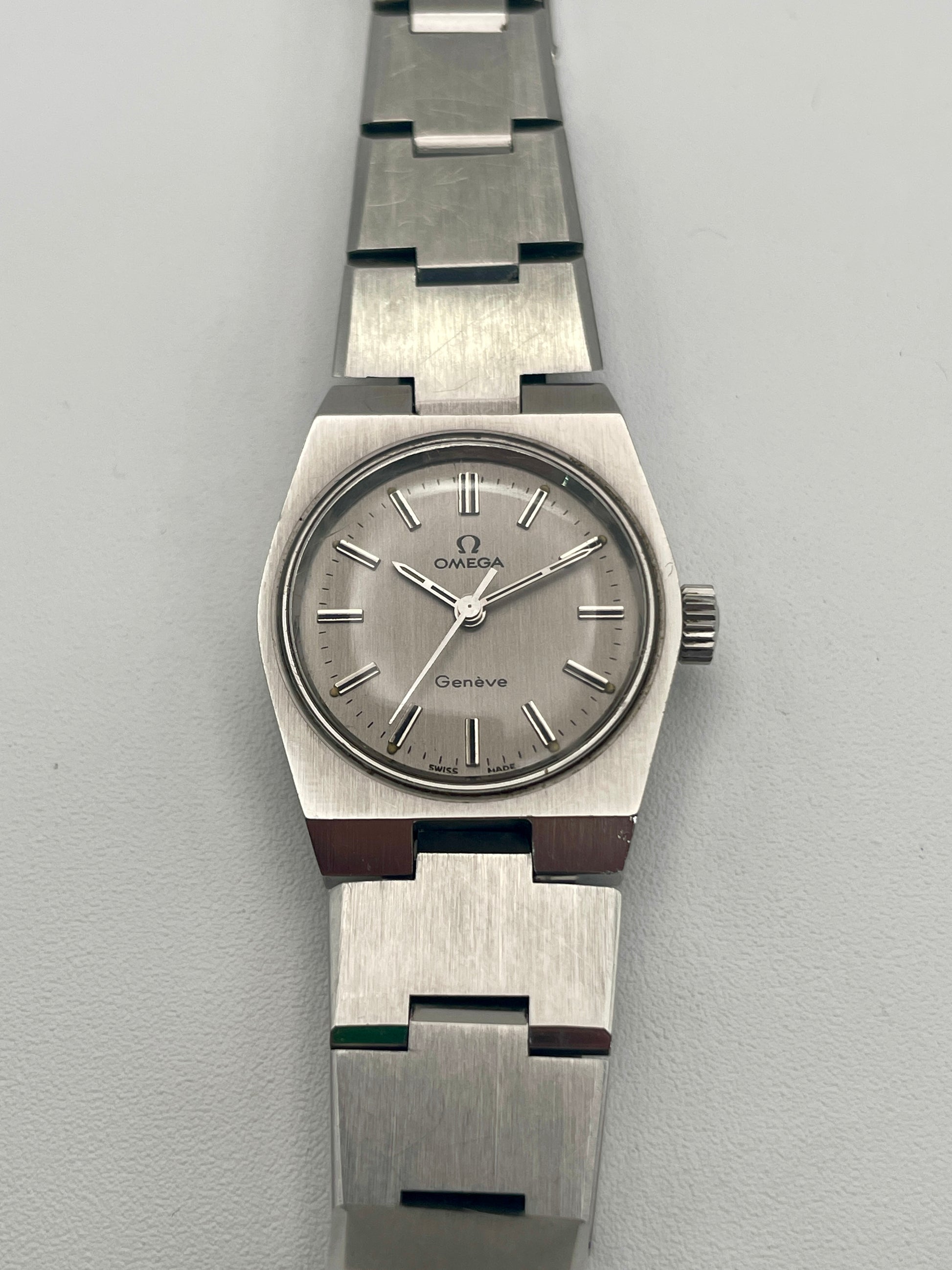 Front view of Omega Geneve 535.0028 vintage watch in stainless steel with Caliber 625 movement, showcasing the grey dial and integrated bracelet.