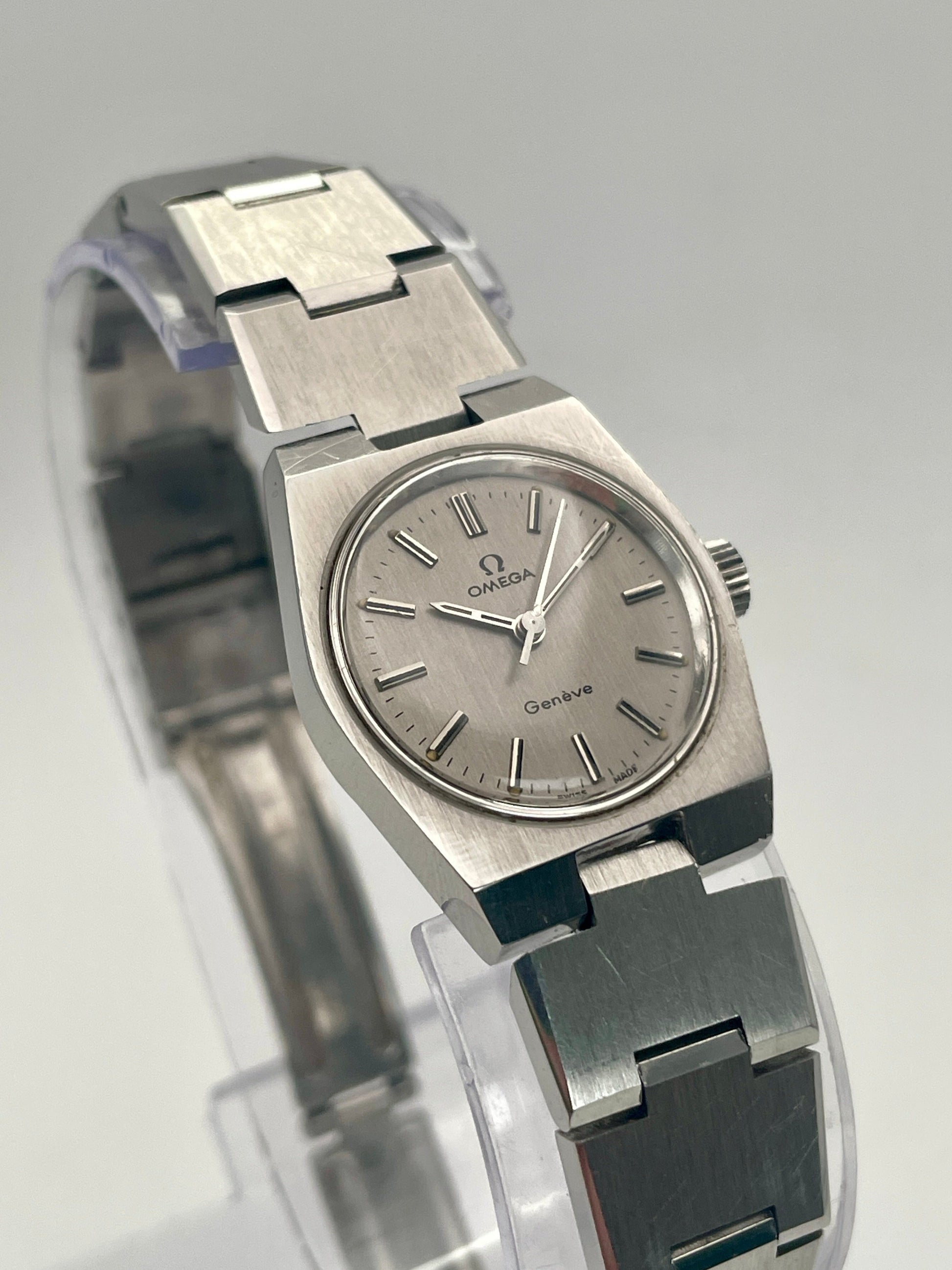 Upright front view of Omega Geneve 535.0028 vintage watch in stainless steel with Caliber 625 movement, showcasing the grey dial and integrated bracelet.