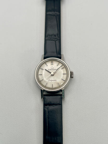 Front view of the Omega Ladymatic Vintage Women's Watch in Steel with a silver sunburst dial and black leather strap.