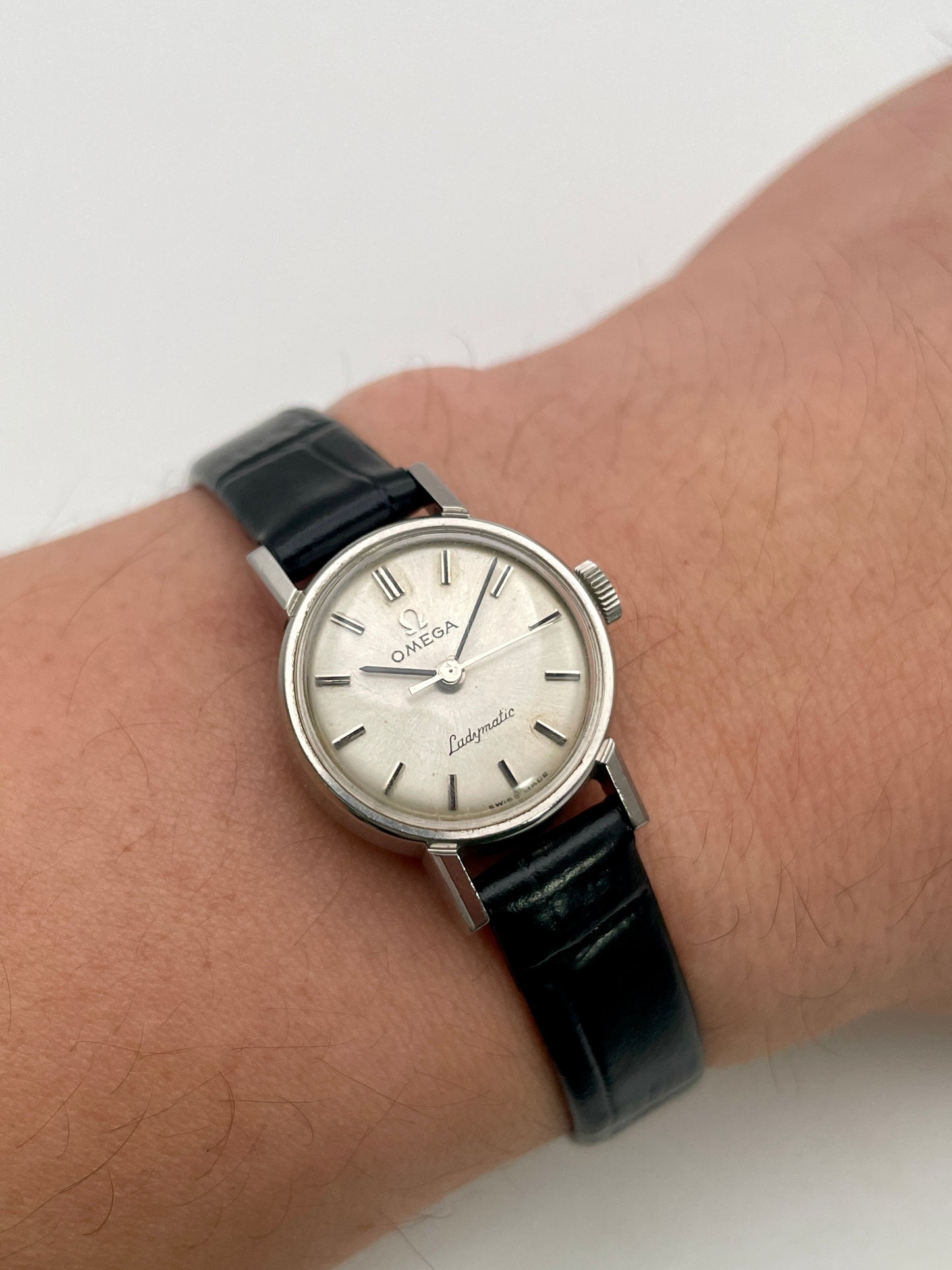 Wrist shot of the Omega Ladymatic Vintage Women's Watch in Steel, displaying its timeless elegance with a black leather strap.