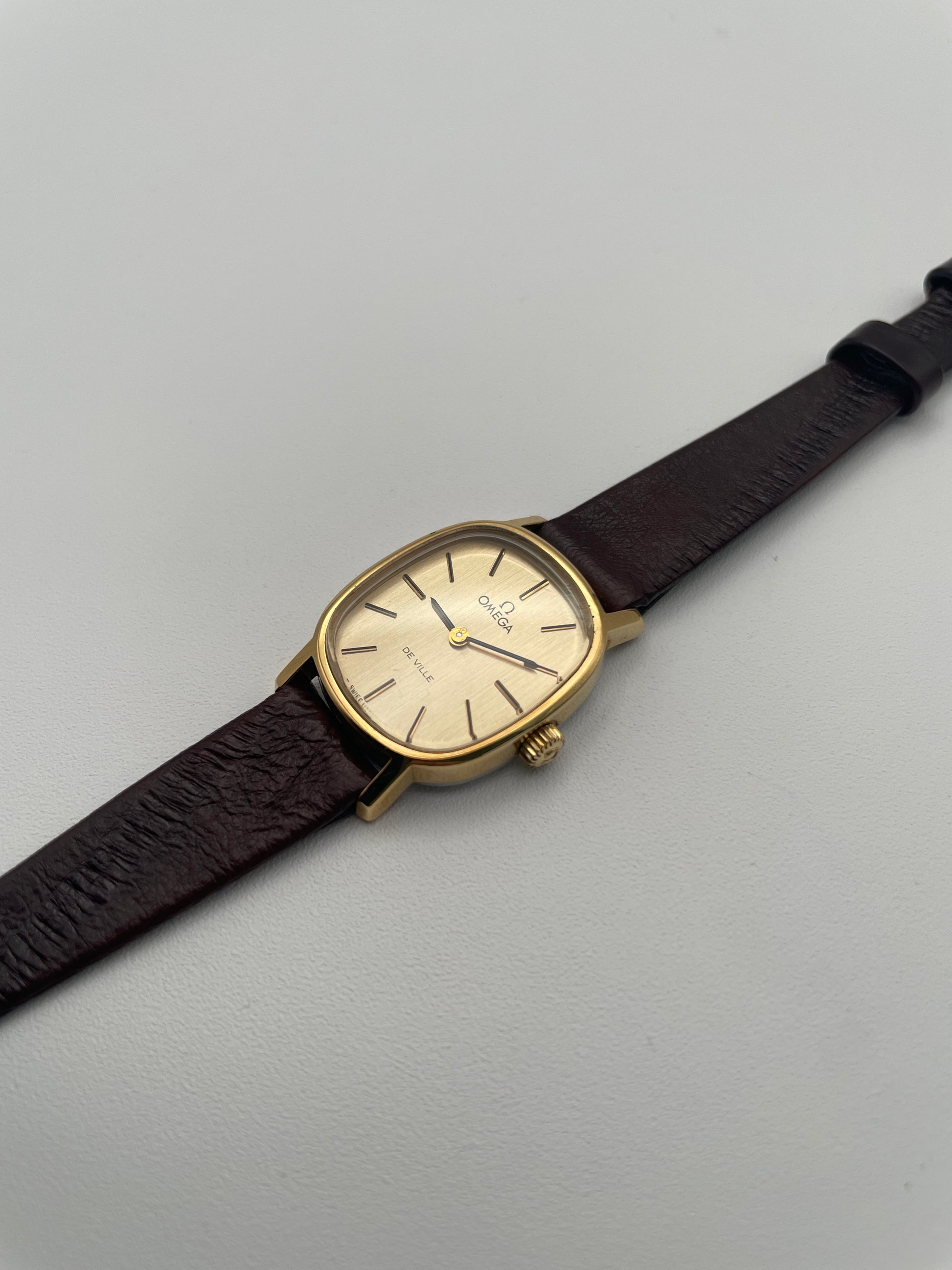 Diagonal view of the Omega De Ville 511.0509 watch, showing the thin profile and gold-tone crown.