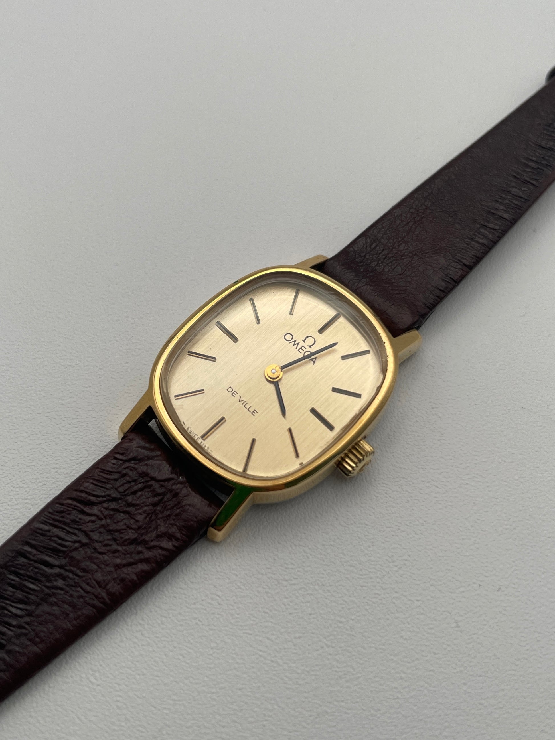 Flat lay of the Omega De Ville 511.0509 watch with a gold case and brown leather strap, providing a clear view of the timepiece.