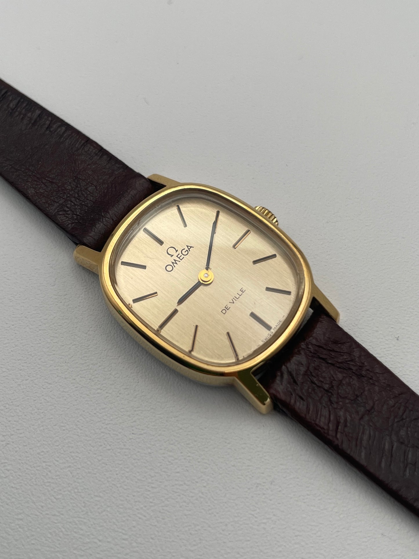 View of the Omega De Ville 511.0509 watch featuring a gold oval case and brown leather strap, showcasing its minimalist dial design.