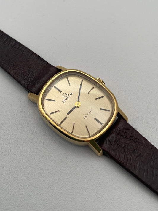 View of the Omega De Ville 511.0509 watch featuring a gold oval case and brown leather strap, showcasing its minimalist dial design.