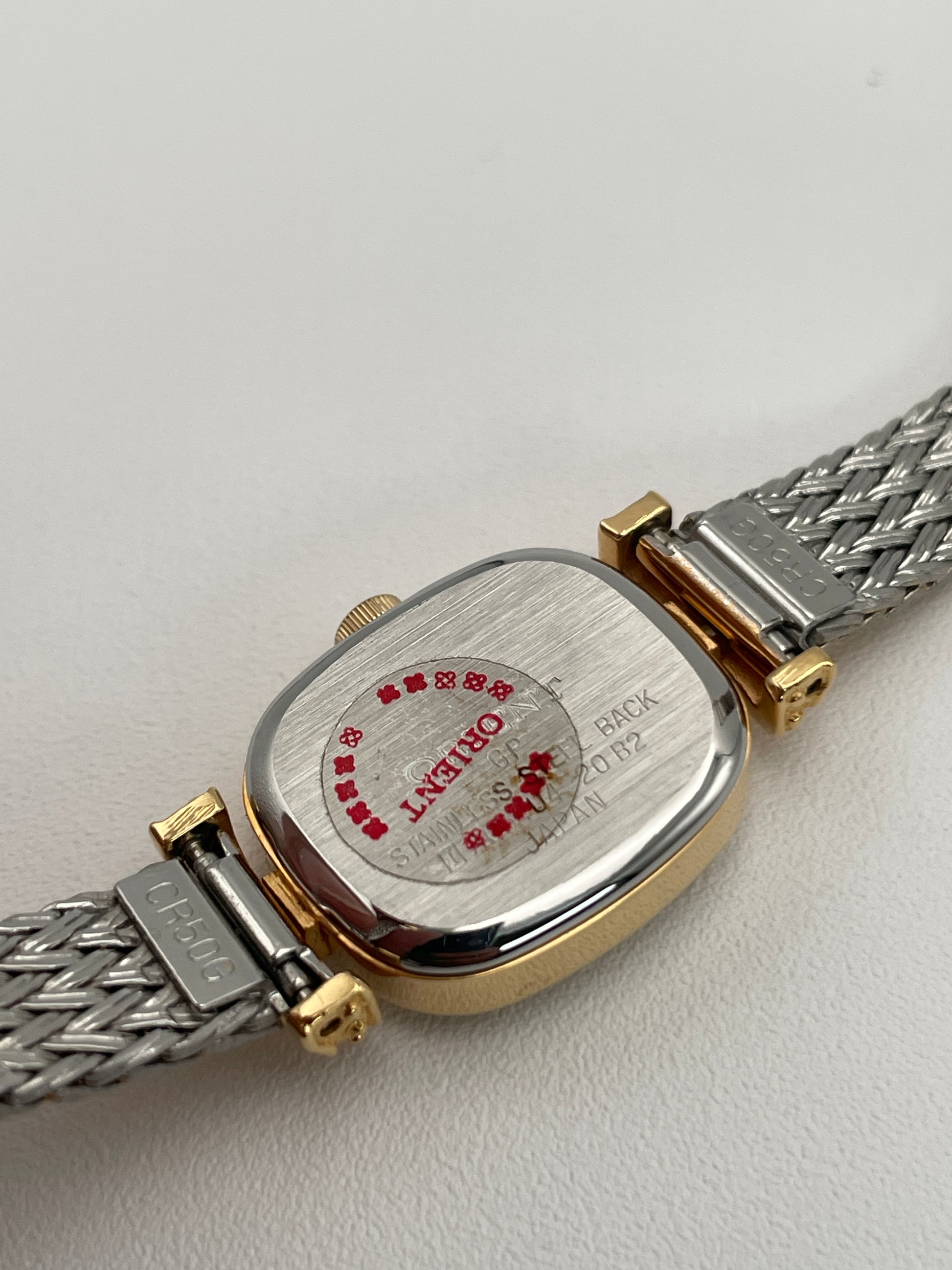 Caseback of Orient Vintage Women's Watch showing stainless steel details with branding and red sticker.