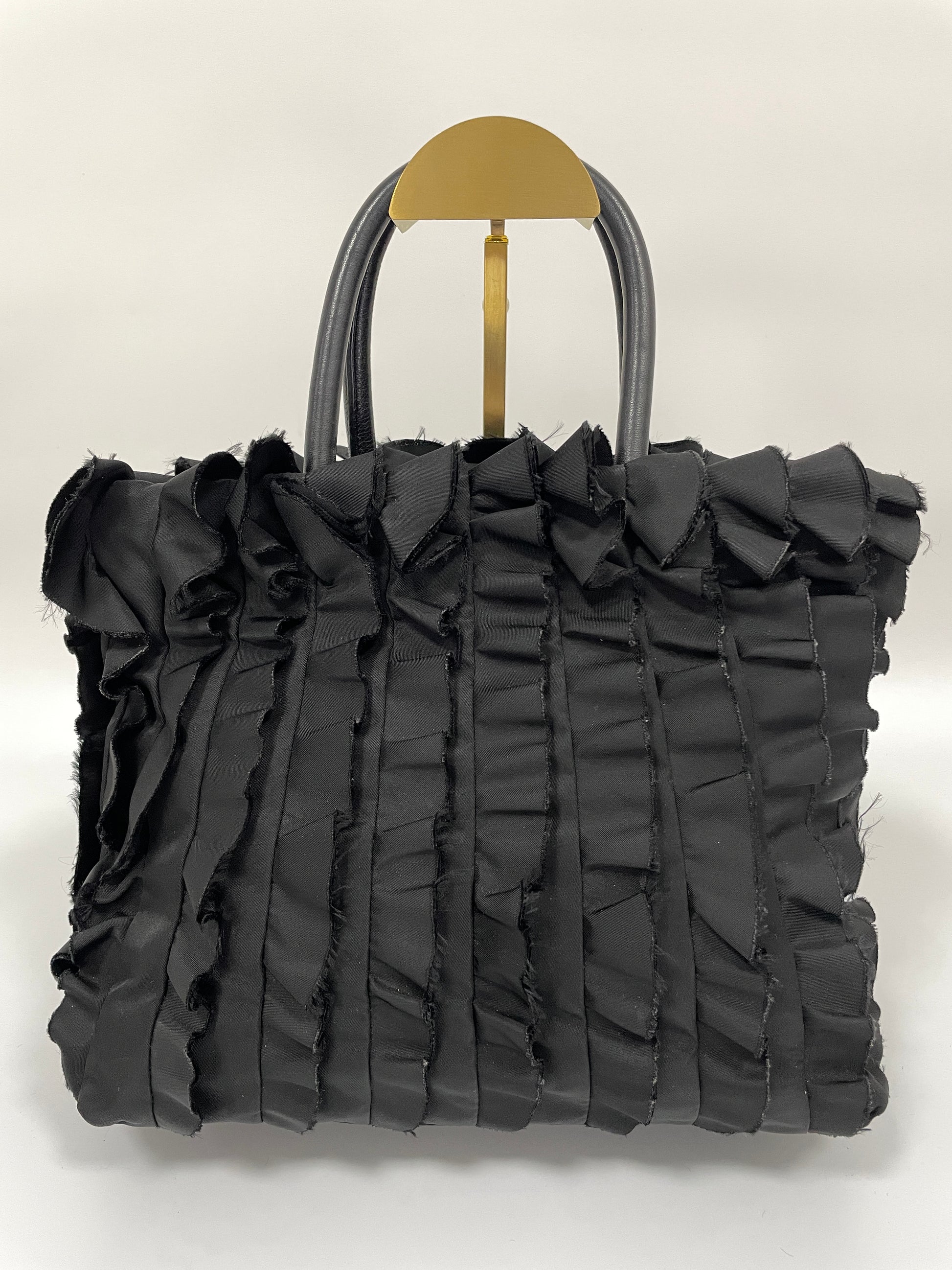 Back view of Prada Tessuto Ruffle Bag in black nylon with a textured ruffled pattern.

