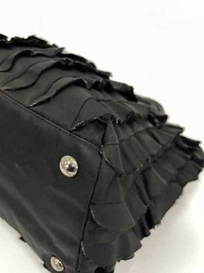 Close-up view of the corner of Prada Tessuto Ruffle Bag in black nylon, featuring protective silver-tone studs.