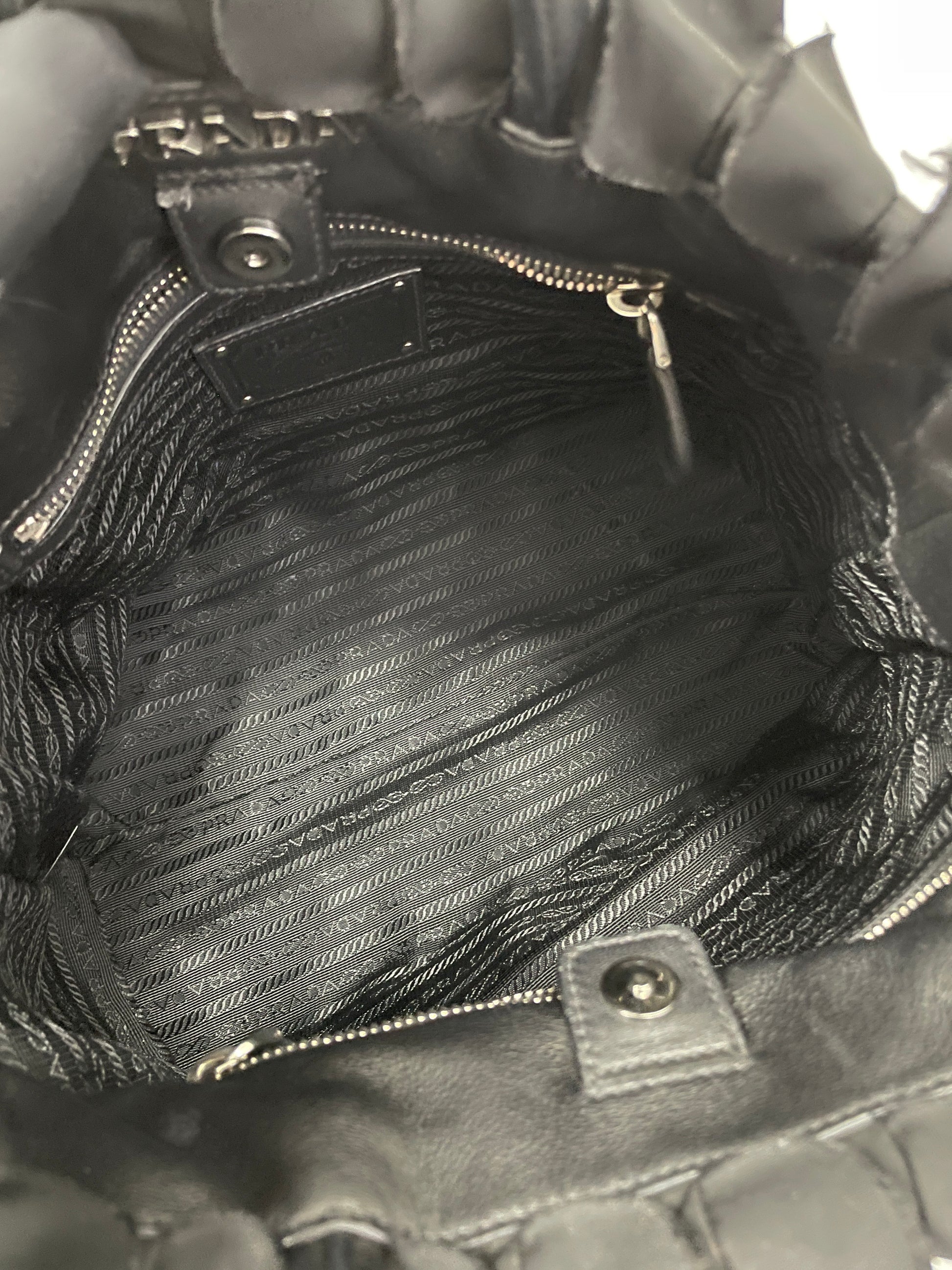 Interior view of the Prada Tessuto Ruffle Bag in black nylon, showcasing its spacious compartment and zipper pocket.