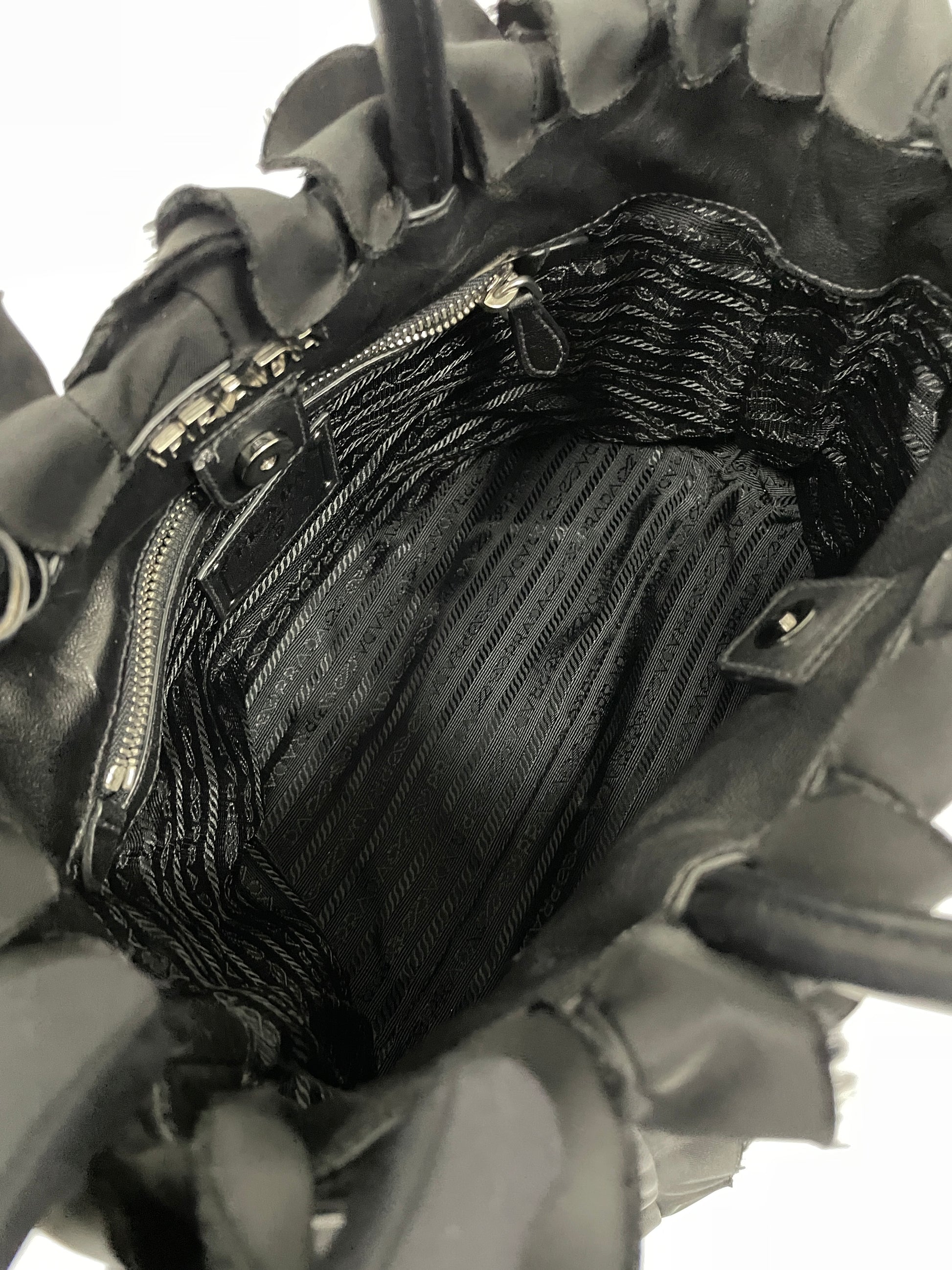 Interior view of the Prada Tessuto Ruffle Bag in black nylon, showcasing its spacious compartment and zipper pocket.