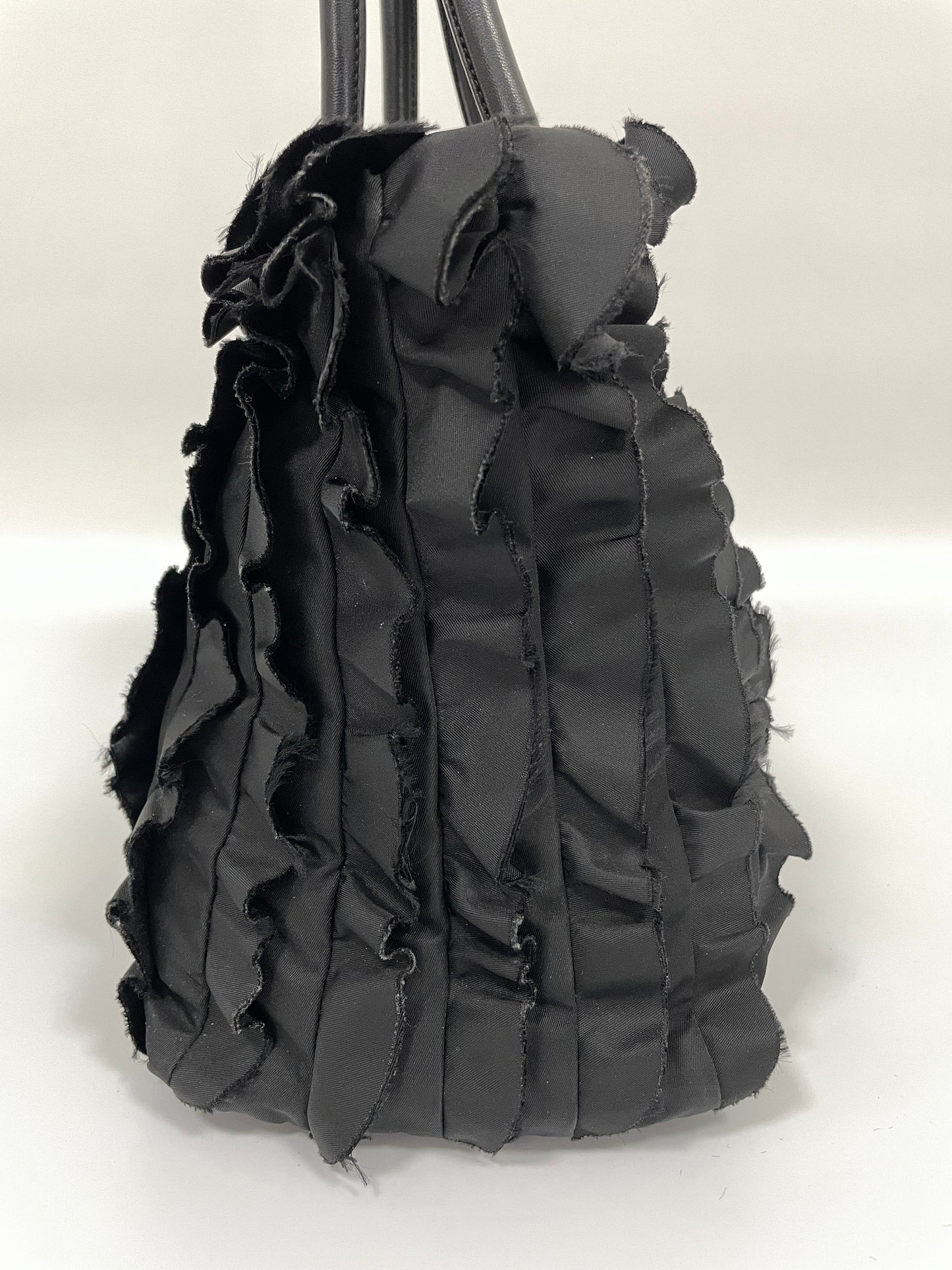 Left side view of Prada Tessuto Ruffle Bag in black nylon highlighting its voluminous ruffled layers.