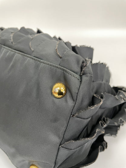 Close-up of the bottom corner detail of the Prada Tessuto Ruffle Bag in grey nylon, showing the ruffle edge and stud.