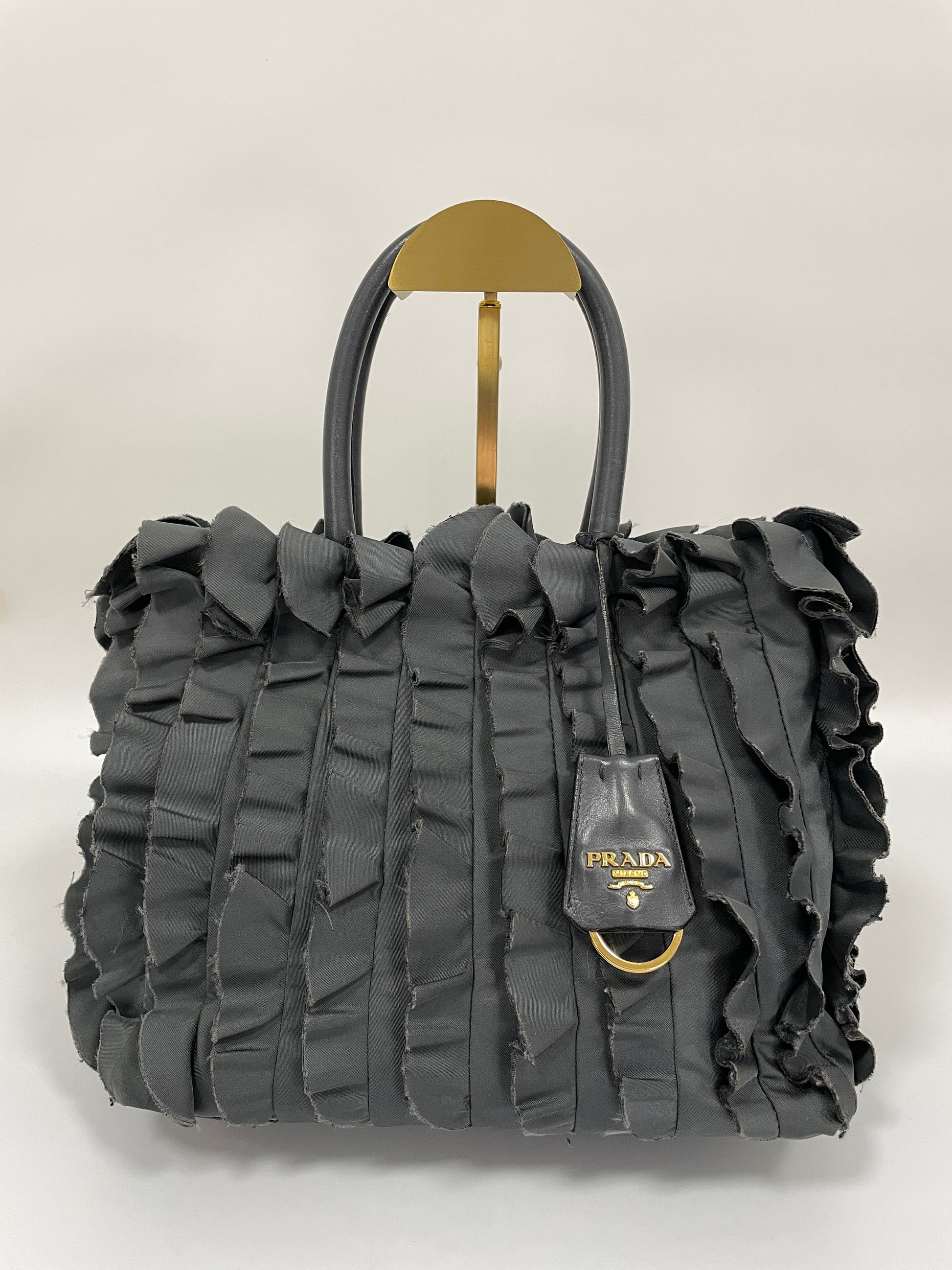 Front view of Prada Tessuto Ruffle Bag in grey nylon with signature ruffle detailing and double leather handles.