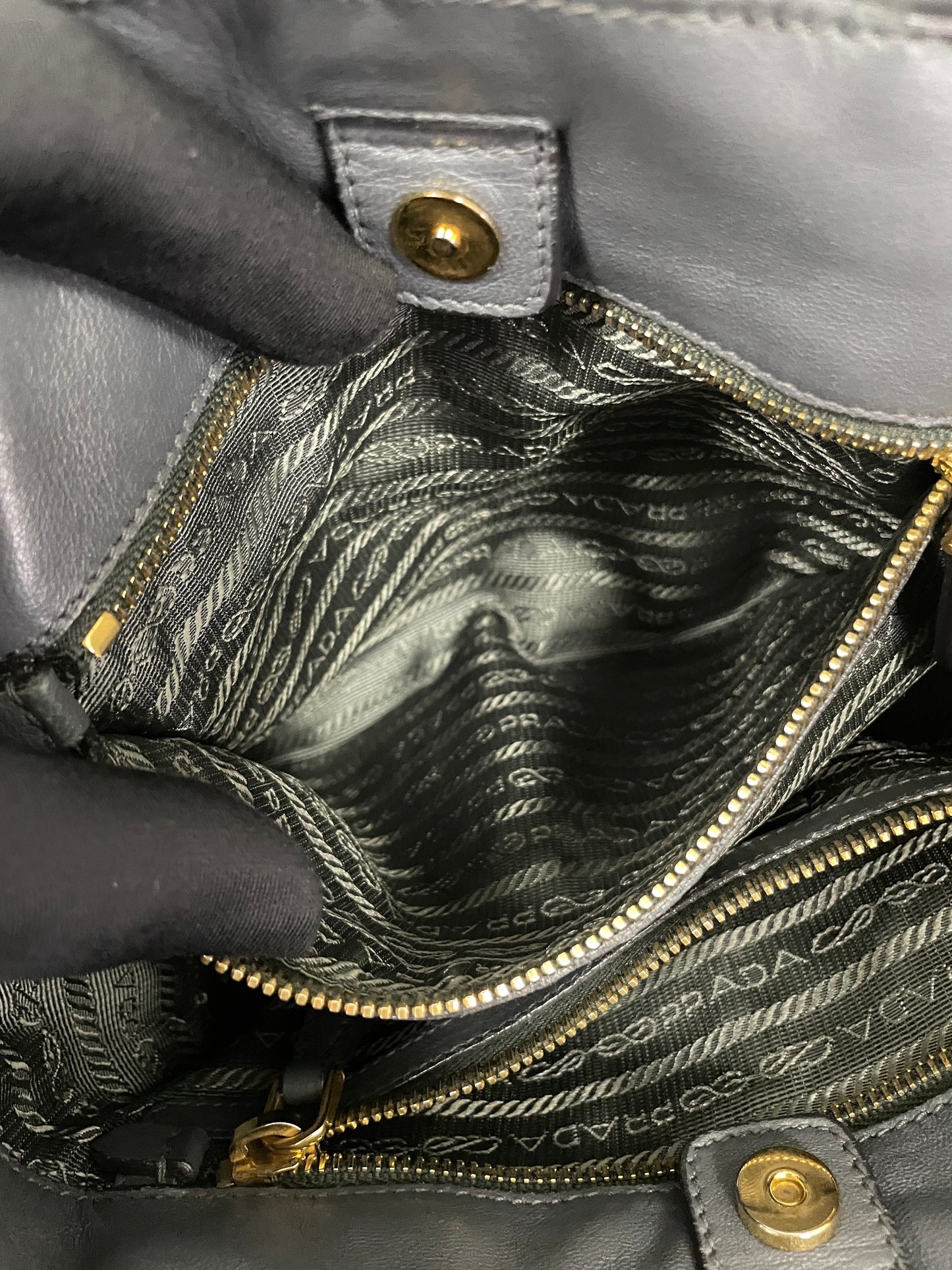 Close-up view of alternate interior zippered pocket inside the Tessuto Ruffle Bag in grey nylon.